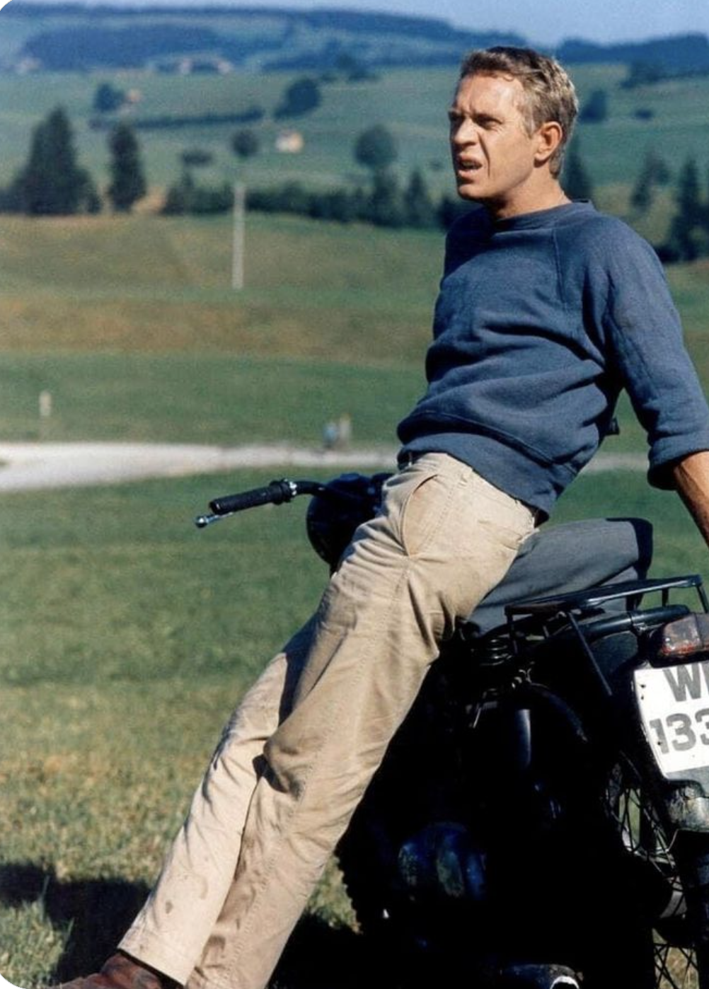 Steve McQueen in The Great Escape, 1963 — tan military trousers, navy crewneck, brown work boots